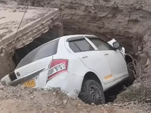 सड़क किनारे गहरे गड्ढे में गिरी कार,VIDEO:ग्रामीणों ने दरवाजा तोड़कर ड्राइवर को निकाला, चेतावनी बोर्ड नहीं लगा होने से हादसा